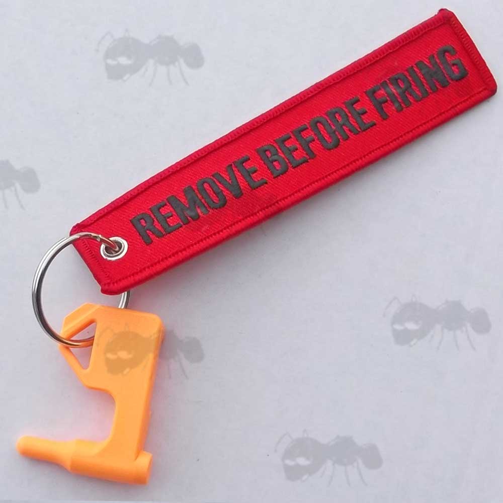Orange Plastic Empty Gun Chamber Safety Plug Tool Fitted with Red Canvas Flag Keychain with Black Embroidered Remove Before Firing Chamber Text