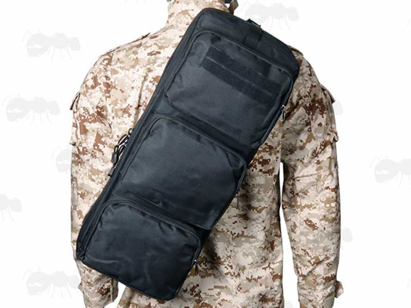 Black Canvas Small Machine Gun Backpack Carry Case Shown Being Carried on Back of a Sand Digital Camo Jacket