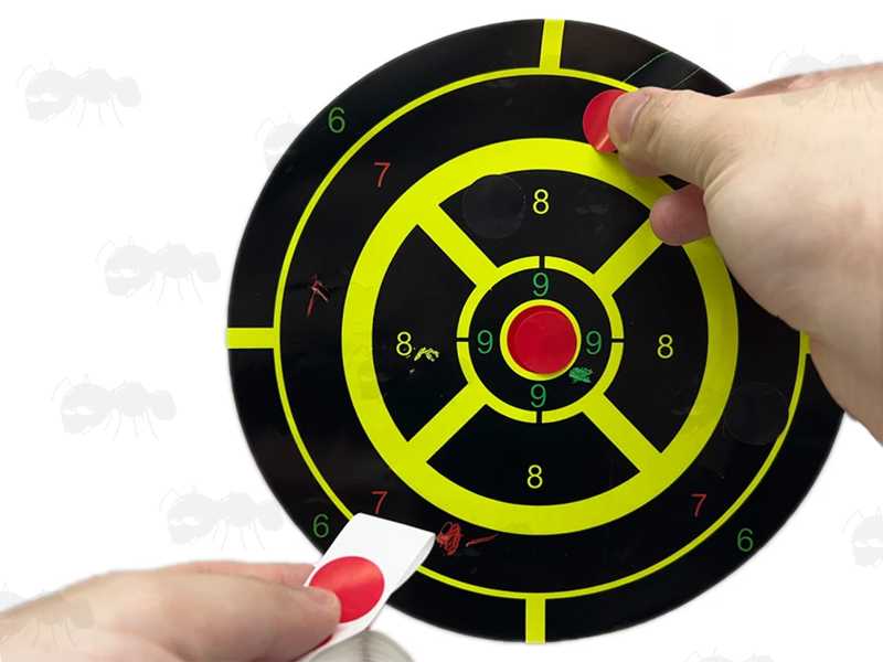 2cm Circular Self Adhesive Reactive Paper Shooting Target Red Repair Cover Up Patches Being Applied to a Paper Target