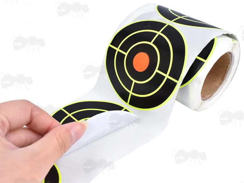 Roll of 200 Circular Self Adhesive Reactive Yellow and Black Paper Shooting Target with Full Circle Bullseye, Shown Being Peeled Off