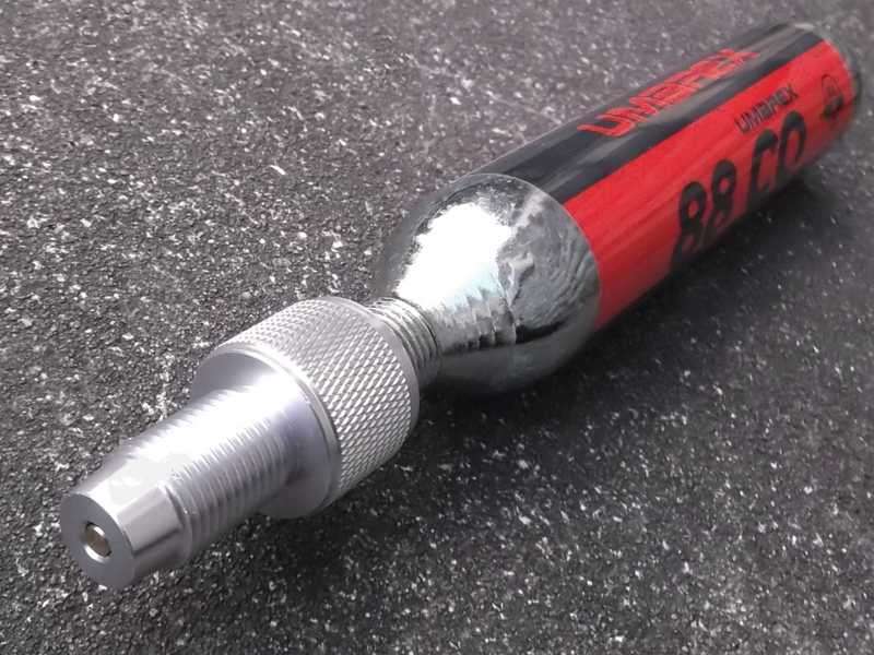 Large 88g Umarex Co2 Capsule with M16x1.5mm Threaded Fitting End, with a Silver Coloured One Way Air Saver Valve Adapter Fitted