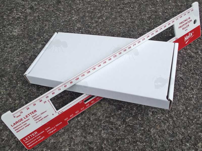 Die-Cut White Cardboard Royal Mail Large Letter DL Sized Postage Box SHown Fitting Through Large Letter Guide Slot