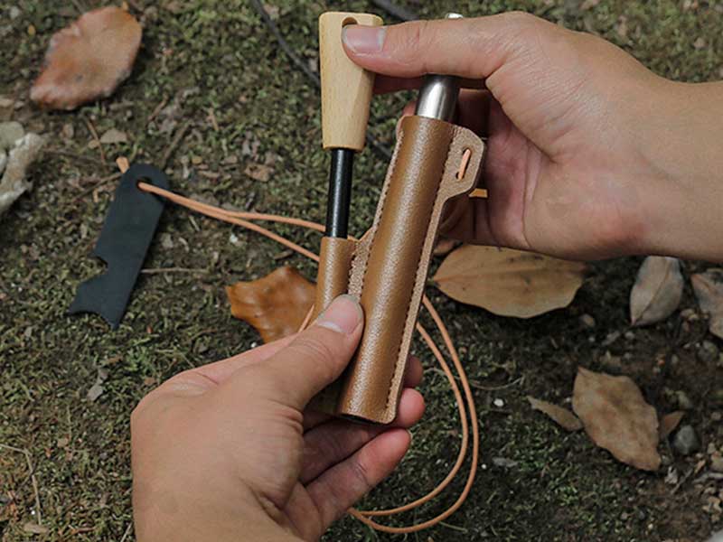 View of The Magnesium Fire Starting Rod with Black Striker Steel and Telescopic Blower Being Removed from it's Faux Leather Sheath