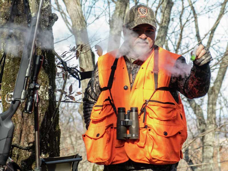 Hunter in High-Vis Jacket Using Primos Wind Checker Bottle