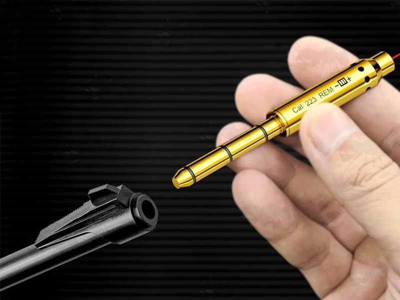 Brass .223 Calibre Rifle Barrel Muzzle Fitting Laser BoreSighter, Shown In Hand, Being Placed in Barrel End