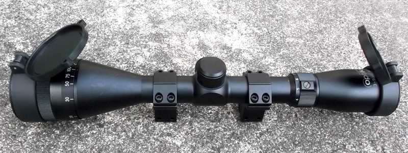 Side View of The Richter Optik 3-9x42AO Adjustable Magnification Rifle Scope with Pair of Dovetail Mounts Fitted and Lens Caps Flipped Open