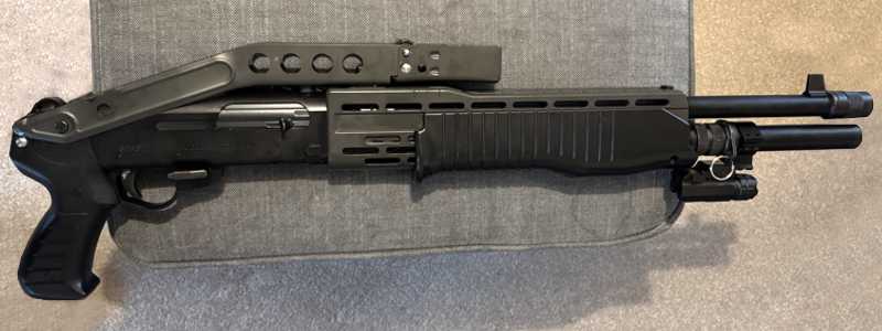 Black Aluminium Body Compact LED Tactical Torch Unit with View of Quick Fitting Lever The Base Weaver / Picatinny Rail Mount Fitting, Shown Fitted to an Airsoft Shotgun Magazine Tube